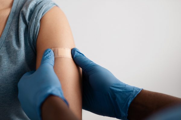 Perosn having a plaster placed on their arm where they got a COVID injection