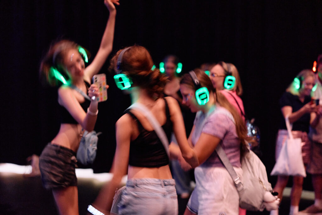 Dancing girls with glowing headphones at a silent disco